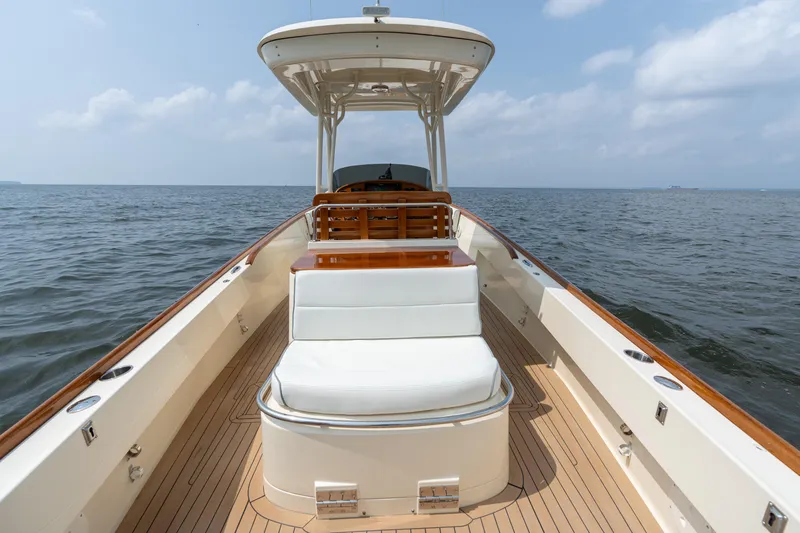 Slide: The Image of 2017 Hinckley Talaria 29C boat on open water, featuring elegant deck and seating. - 14