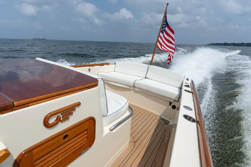 Slide: The Image of 2017 Hinckley Talaria 29C cruising on open water with American flag waving. - 17