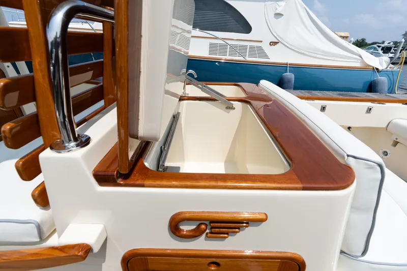 Slide: The Image of 2017 Hinckley Talaria 29C boat interior with elegant wood finish and storage compartment. - 18