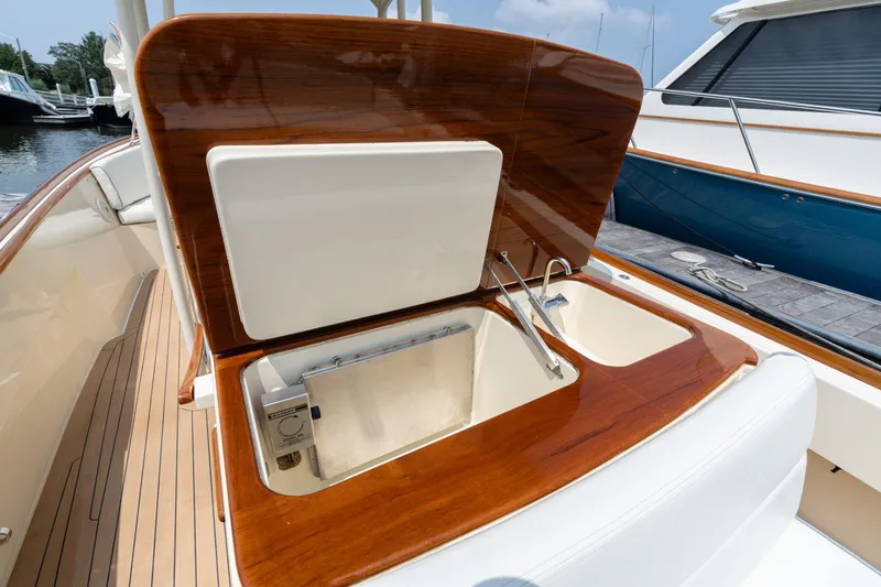 Slide: The Image of 2017 Hinckley Talaria 29C boat interior with open storage compartment and wooden finish. - 19