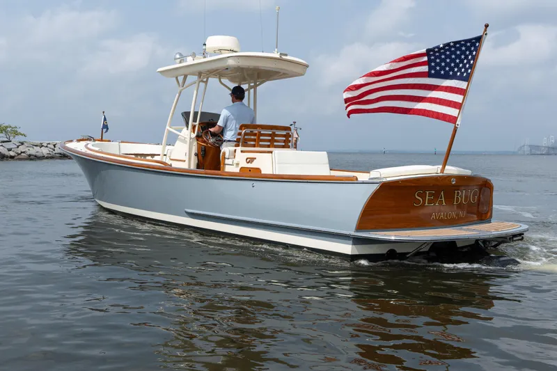 Slide: The Image of 2017 Hinckley Talaria 29C boat with American flag, cruising on calm waters. - 2