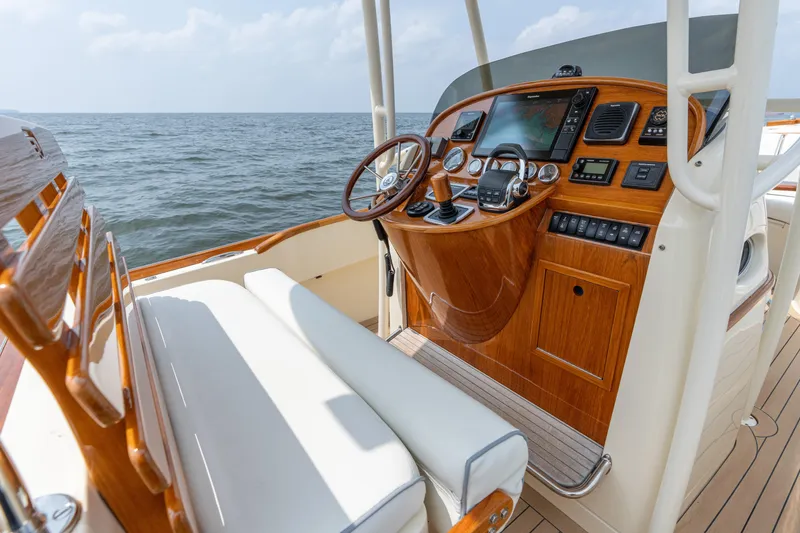 Slide: The Image of 2017 Hinckley Talaria 29C boat helm with wooden dashboard and ocean view. - 24