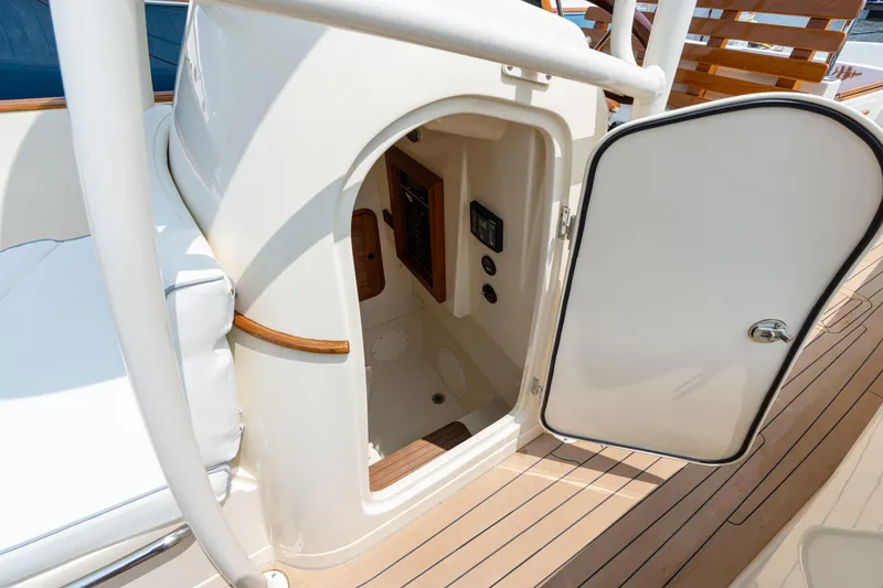 Slide: The Image of 2017 Hinckley Talaria 29C boat interior with open door, showcasing elegant wood and white design. - 28