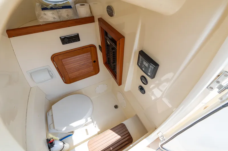 Slide: The Image of 2017 Hinckley Talaria 29C boat interior with toilet and control panel. - 29