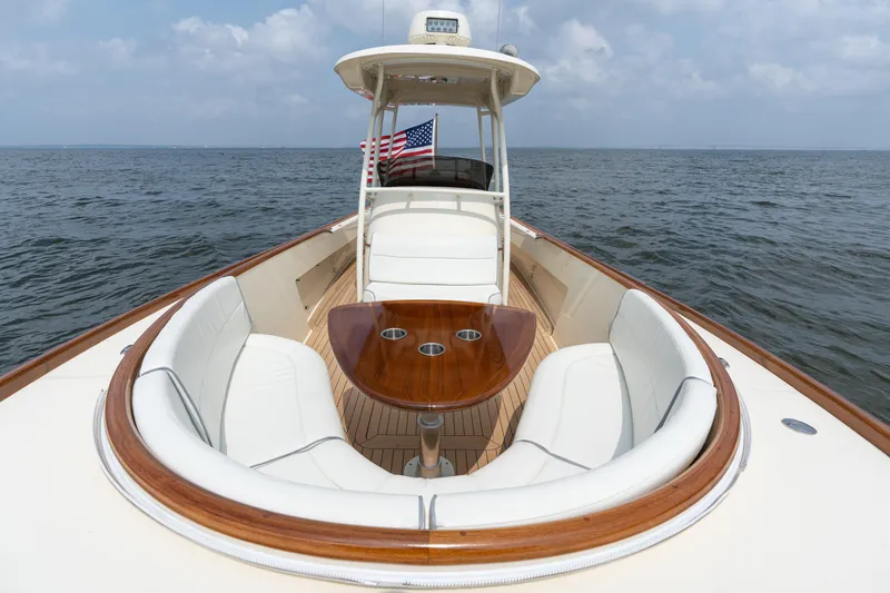 Slide: The Image of 2017 Hinckley Talaria 29C boat with elegant seating and wooden table on open water. - 30