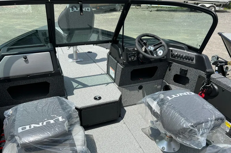 Slide: The Image of 2026 Lund 1875 Impact XS Sport boat interior with steering console and seating. - 12