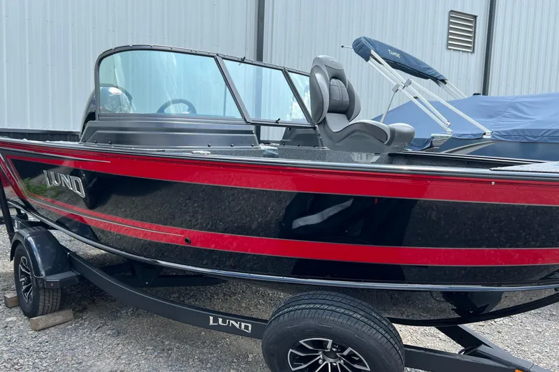 Slide: The Image of 2026 Lund 1875 Impact XS Sport boat with red and black design on trailer. - 20