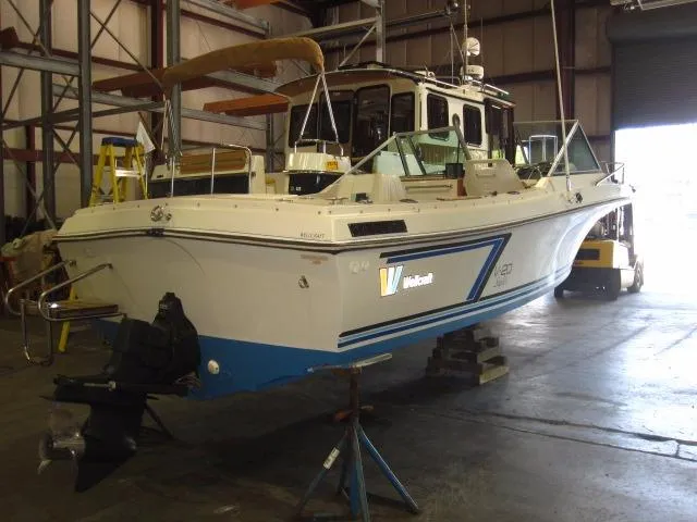 Slide: The Image of 1987 Wellcraft Step V 20 boat in a warehouse, elevated on stands. - 5