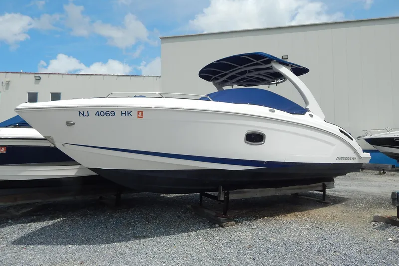 Slide: The Image of 2016 Chaparral 277 SSX boat on display, white with blue accents, parked outdoors. - 0