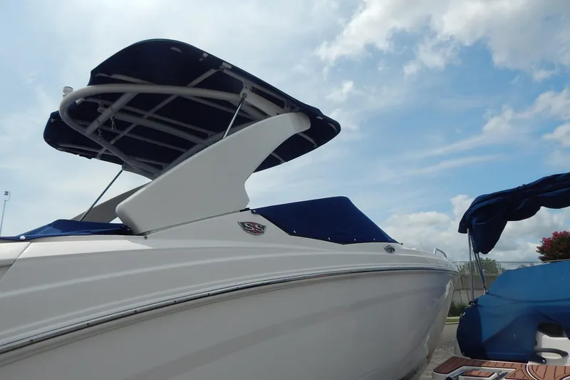 Slide: The Image of 2016 Chaparral 277 SSX boat with blue canopy under a cloudy sky. - 11