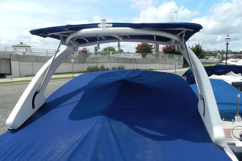 Slide: The Image of 2016 Chaparral 277 SSX boat with blue cover and arch, docked outdoors. - 13