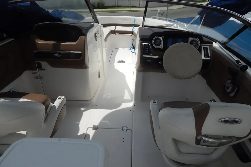 Slide: The Image of 2016 Chaparral 277 SSX boat interior with white and brown seating, modern dashboard. - 15
