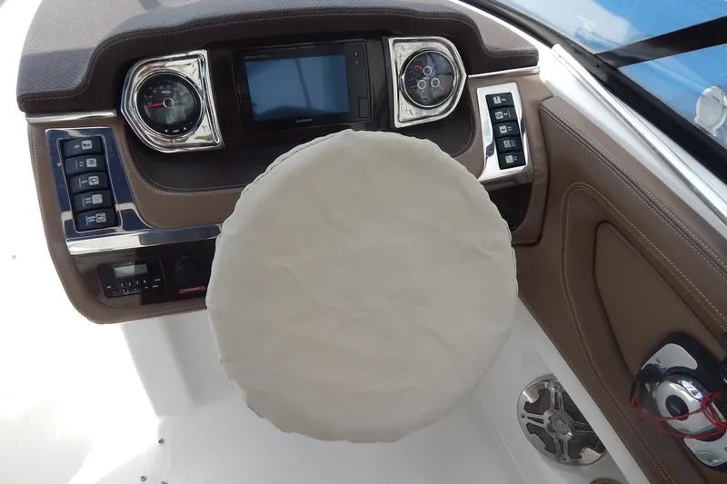 Slide: The Image of 2016 Chaparral 277 SSX boat dashboard with covered steering wheel and control panel. - 18