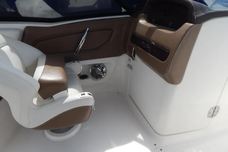 Slide: The Image of 2016 Chaparral 277 SSX boat interior with brown and white seating and dashboard. - 21