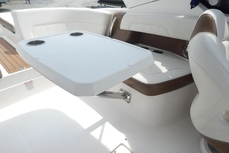 Slide: The Image of 2016 Chaparral 277 SSX boat interior with white seating and table with cup holders. - 22
