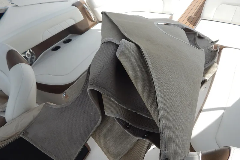 Slide: The Image of 2016 Chaparral 277 SSX boat interior with folded canvas cover and white seating. - 32