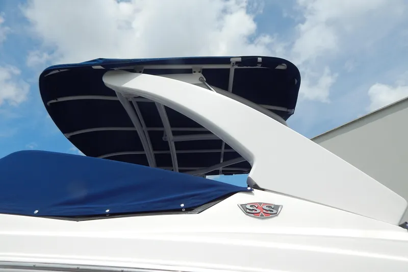 Slide: The Image of 2016 Chaparral 277 SSX boat with blue canopy and SSX emblem under a cloudy sky. - 4