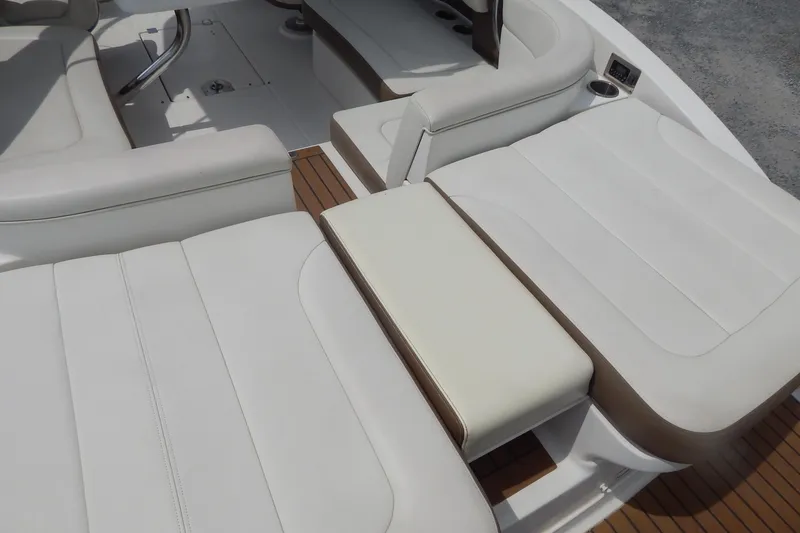 Slide: The Image of 2016 Chaparral 277 SSX boat interior with white cushioned seating and wood accents. - 49