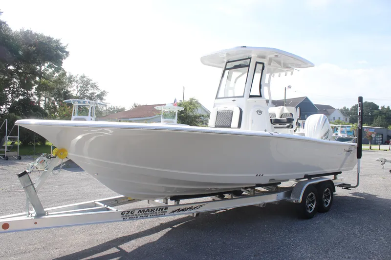 The Image of 2026 Tidewater 2500 Carolina Bay boat on trailer, parked outdoors under blue sky. - 0