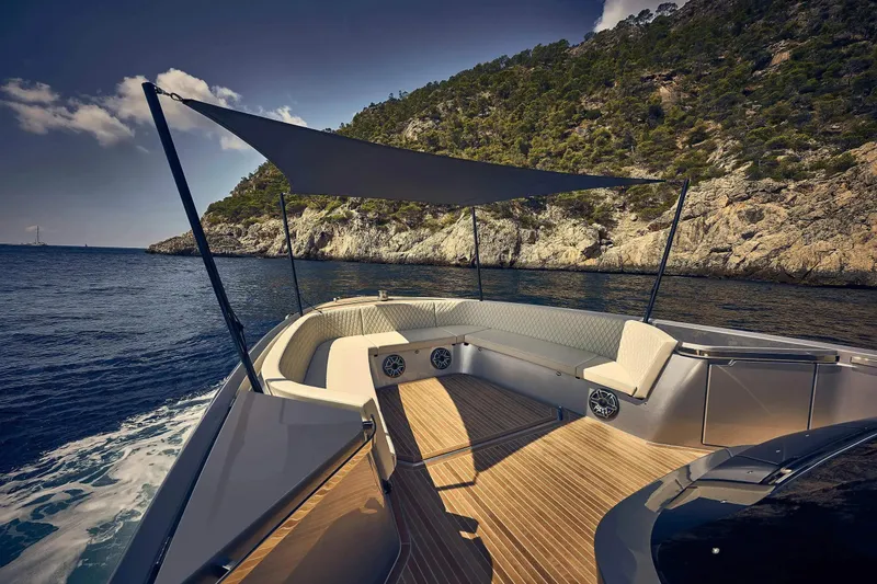 Slide: The Image of Luxurious 2023 Frauscher 1414 Demon yacht cruising near rocky coastline under a sunshade. - 2