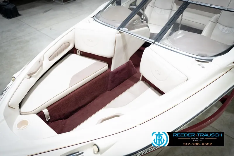 Slide: The Image of 1998 Regal 1700 LSR boat interior with white and maroon seating, Reeder-Trausch Marine logo. - 11