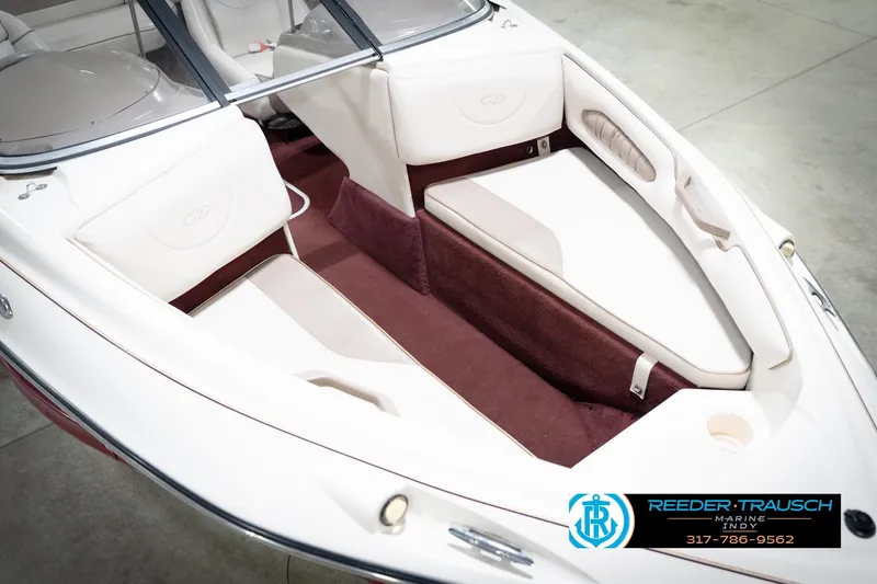Slide: The Image of 1998 Regal 1700 LSR boat interior with white and maroon seating, Reeder-Trausch Marine logo. - 12