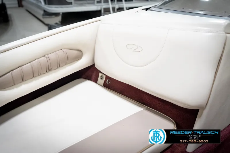 Slide: The Image of 1998 Regal 1700 LSR boat interior with white and maroon seating, Reeder-Trausch Marine logo. - 39