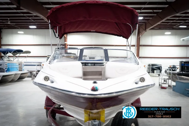 Slide: The Image of 1998 Regal 1700 LSR boat with maroon canopy in indoor showroom. - 4