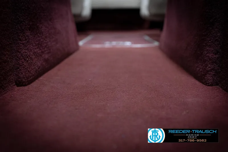 Slide: The Image of Maroon carpet interior of a 1998 Regal 1700 LSR boat, featuring Reeder-Trausch Marine logo. - 43
