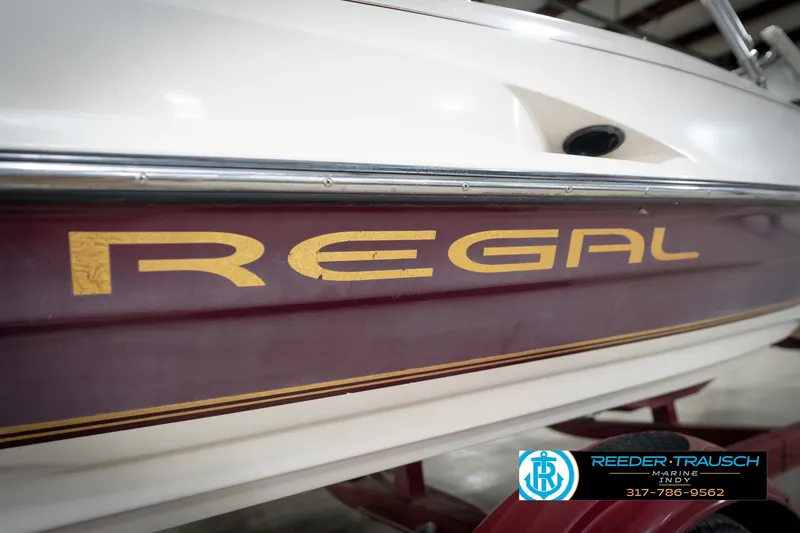 Slide: The Image of 1998 Regal 1700 LSR boat with maroon and gold detailing, displayed indoors. - 46