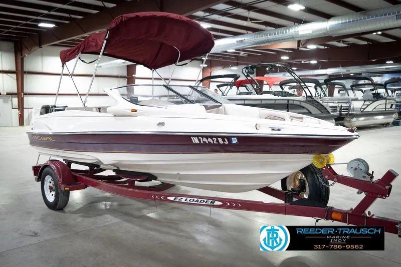 Slide: The Image of 1998 Regal 1700 LSR boat with maroon canopy on trailer in indoor showroom. - 5