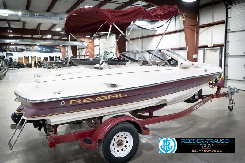 Slide: The Image of 1998 Regal 1700 LSR boat with canopy on trailer in indoor showroom. - 7