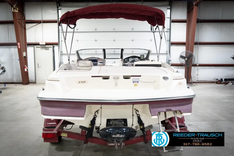 Slide: The Image of 1998 Regal 1700 LSR boat in a garage, featuring a maroon canopy and trailer. - 8