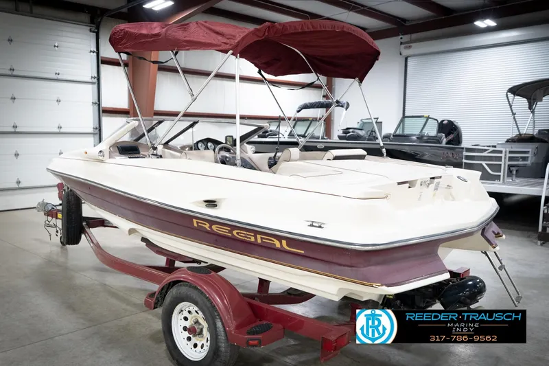 Slide: The Image of 1998 Regal 1700 LSR boat with maroon canopy on trailer in indoor showroom. - 9