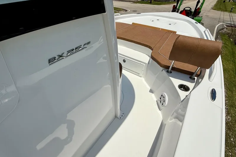 Slide: The Image of 2026 Sea Hunt BX25FS boat interior with brown seating and sleek white design. - 17