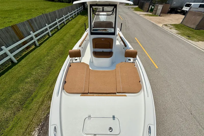 Slide: The Image of 2026 Sea Hunt BX25FS boat with tan seating, parked on a road beside a grassy area. - 18