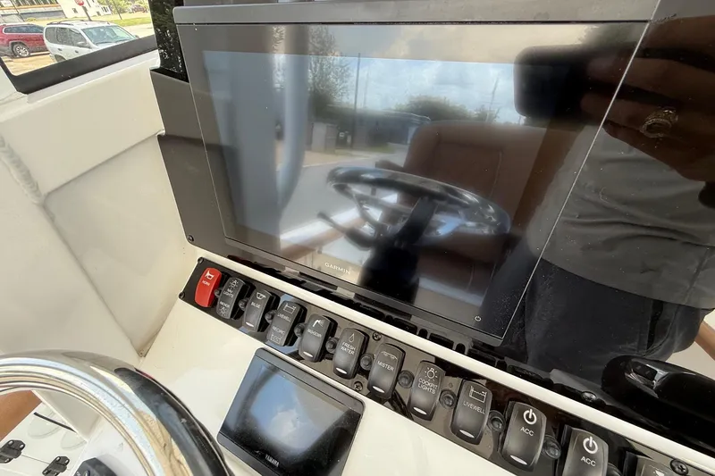 Slide: The Image of Control panel of 2026 Sea Hunt BX25FS boat with Garmin display and switches. - 19