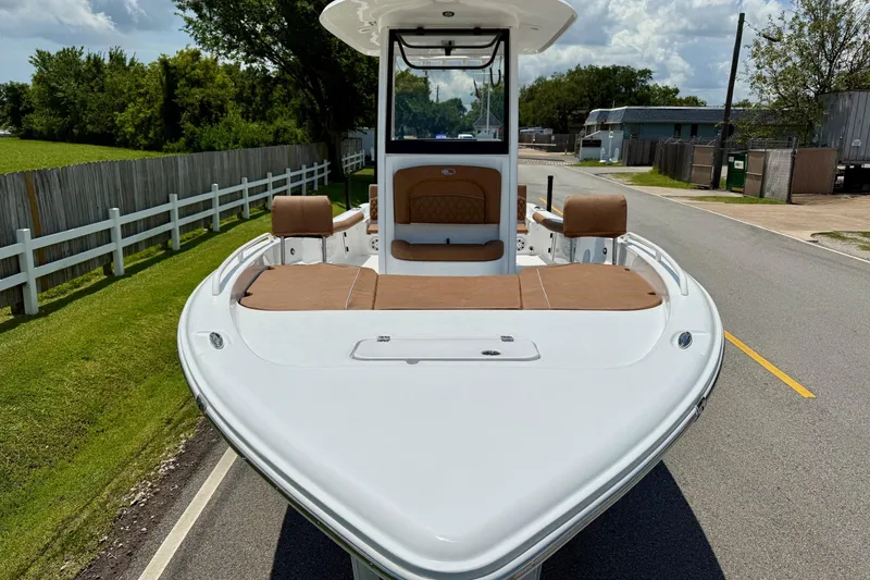 Slide: The Image of 2026 Sea Hunt BX25FS boat with brown seating, parked on a road. - 6