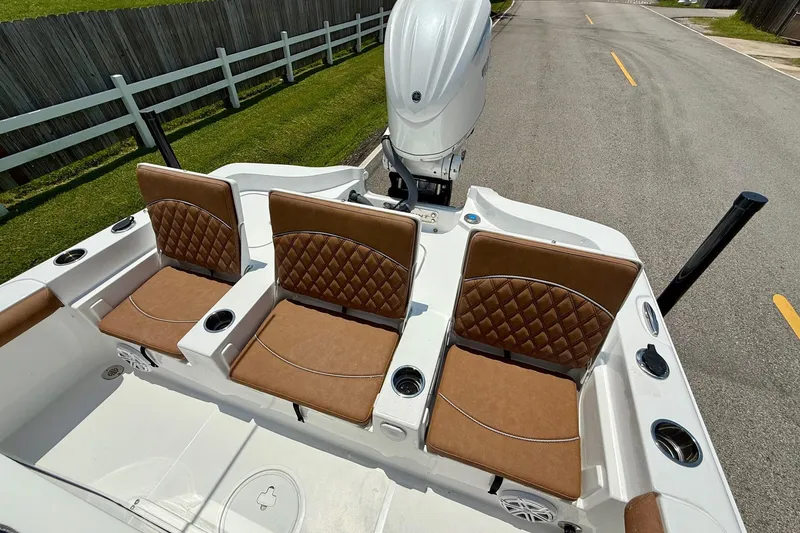 Slide: The Image of 2026 Sea Hunt BX25FS boat with brown cushioned seats and outboard motor. - 7