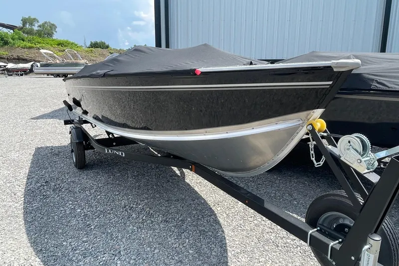 The Image of 2026 Lund 1600 Fury SS boat on trailer, covered and parked outdoors. - 1