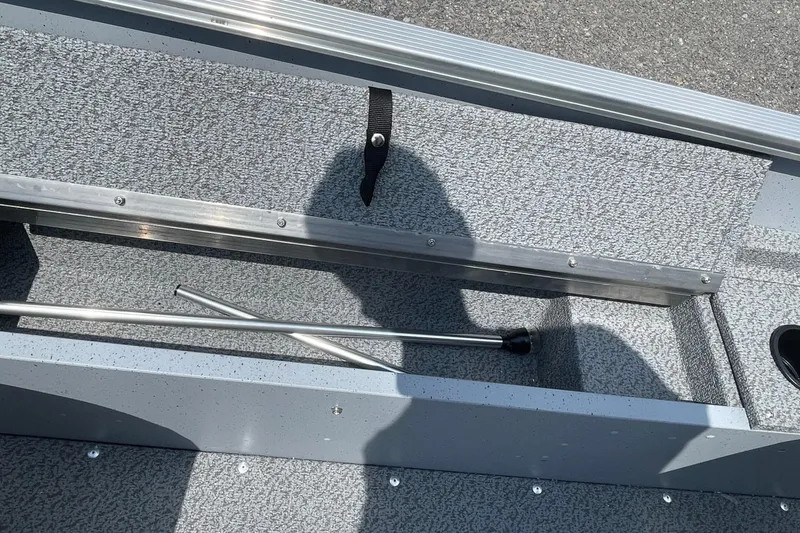 Slide: The Image of Interior of 2026 Lund 1600 Fury SS boat showing storage compartment and metal rods. - 11
