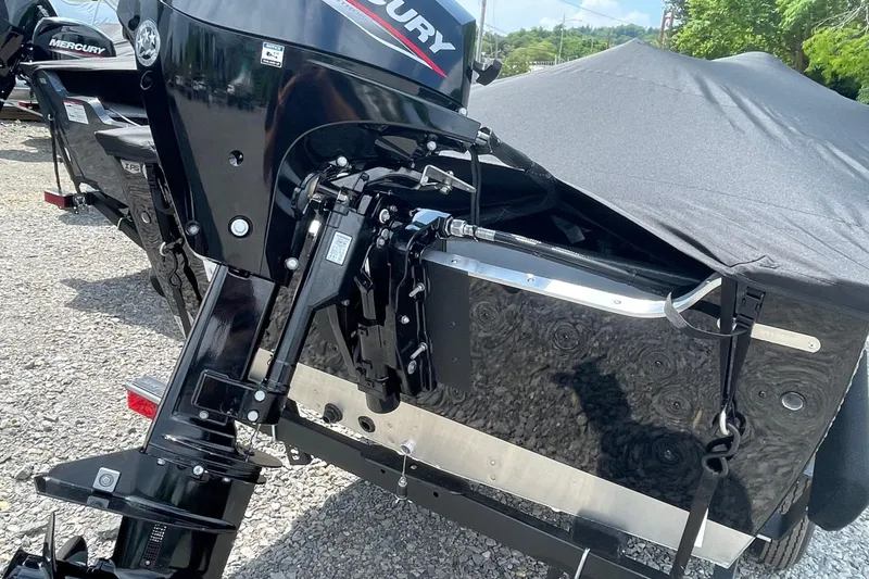 Slide: The Image of 2026 Lund 1600 Fury SS boat with Mercury outboard motor, covered and parked on gravel. - 3