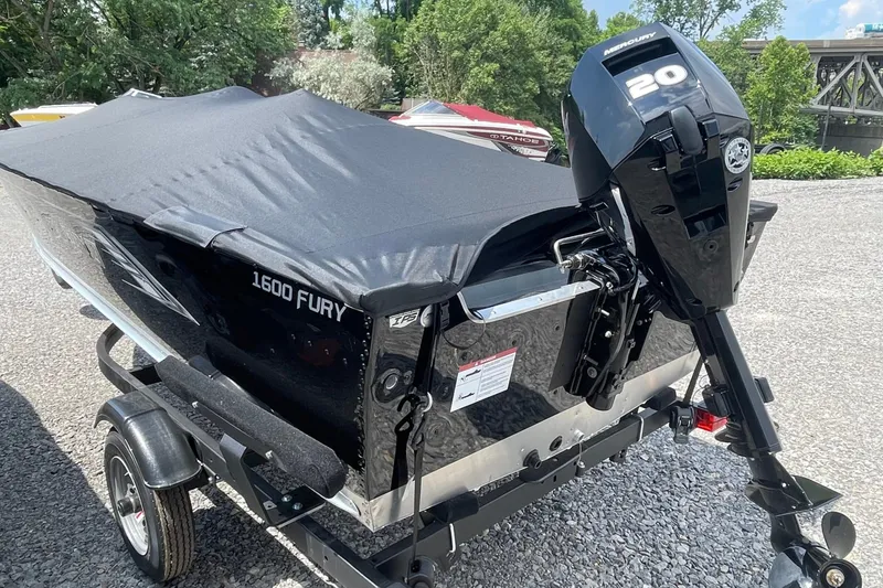 Slide: The Image of 2026 Lund 1600 Fury SS boat with Mercury 20 outboard motor, covered and on trailer. - 4