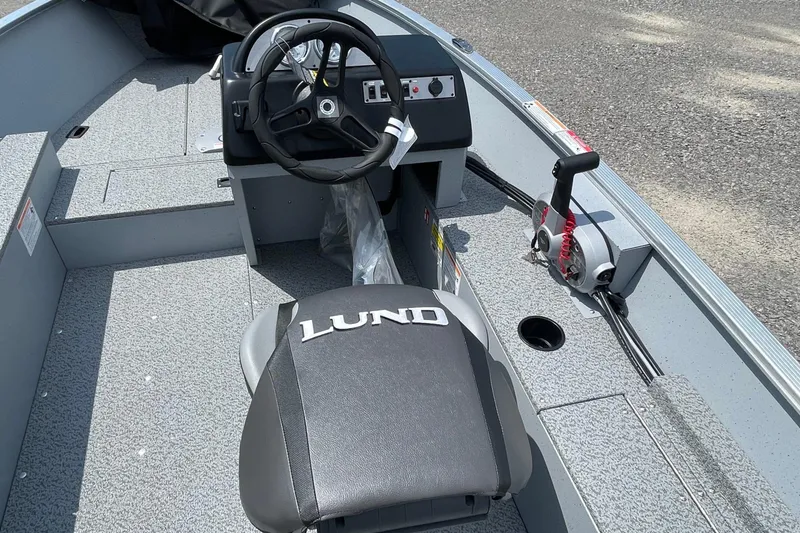 Slide: The Image of 2026 Lund 1600 Fury SS boat interior with steering wheel and control panel. - 6