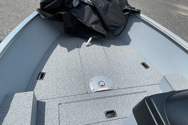 Slide: The Image of 2026 Lund 1600 Fury SS boat interior with gray flooring and storage compartments. - 7