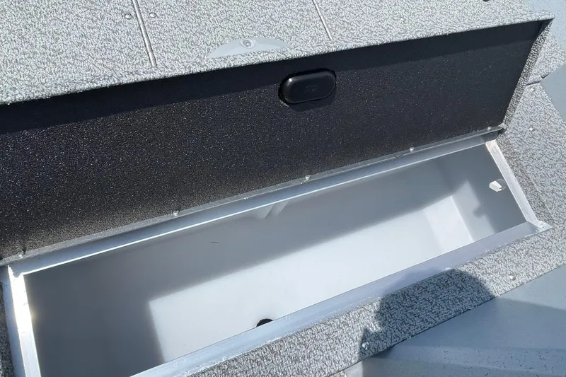 Slide: The Image of 2026 Lund 1600 Fury SS boat storage compartment, open and empty, with textured surface. - 8