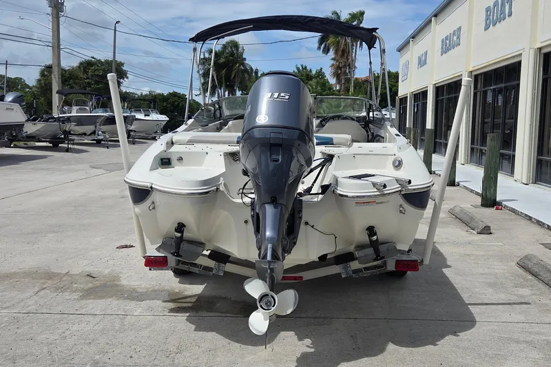 Slide: The Image of 2013 Stingray 194 LX boat with outboard motor, parked at a marina. - 10