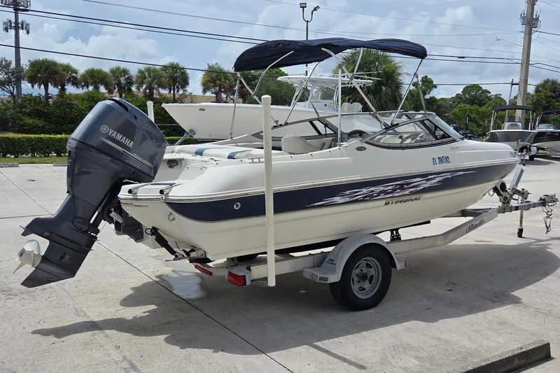 Slide: The Image of 2013 Stingray 194 LX boat with Yamaha outboard motor on trailer, parked outdoors. - 2