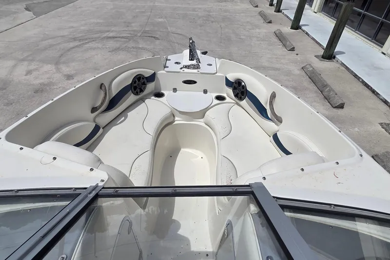Slide: The Image of 2013 Stingray 194 LX boat interior with seating and speakers, docked on concrete. - 7