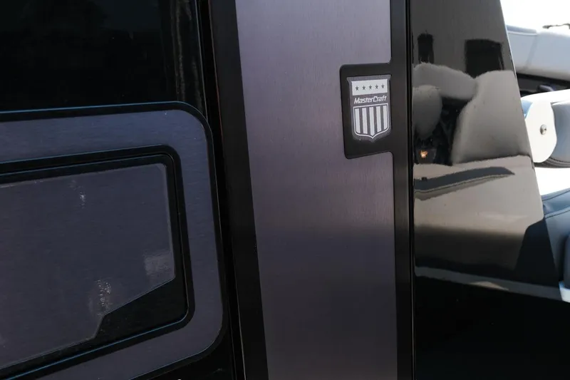Slide: The Image of 2023 MasterCraft XStar boat detail with logo and sleek black finish. - 13